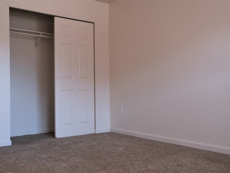 A bedroom with carpet  and sliding door closet